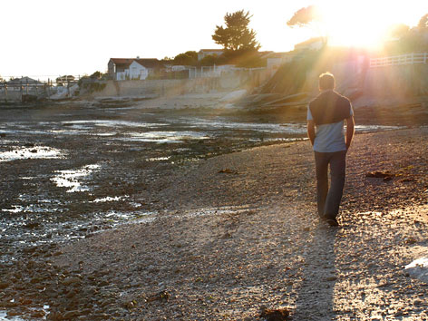 A man walks along the beach in Charente-Maritime department, France