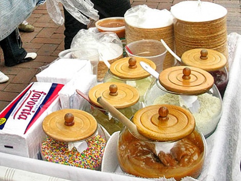 A street cart with jars of toppings for fresh obleas on the street in Bogota.