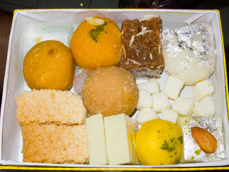 A box of Indian sweets including burfi, milk cake, and peda from Anupama in Delhi, India. 